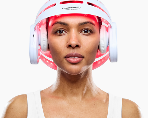 Woman using CurrentBody LED Hair Growth Helmet on her head